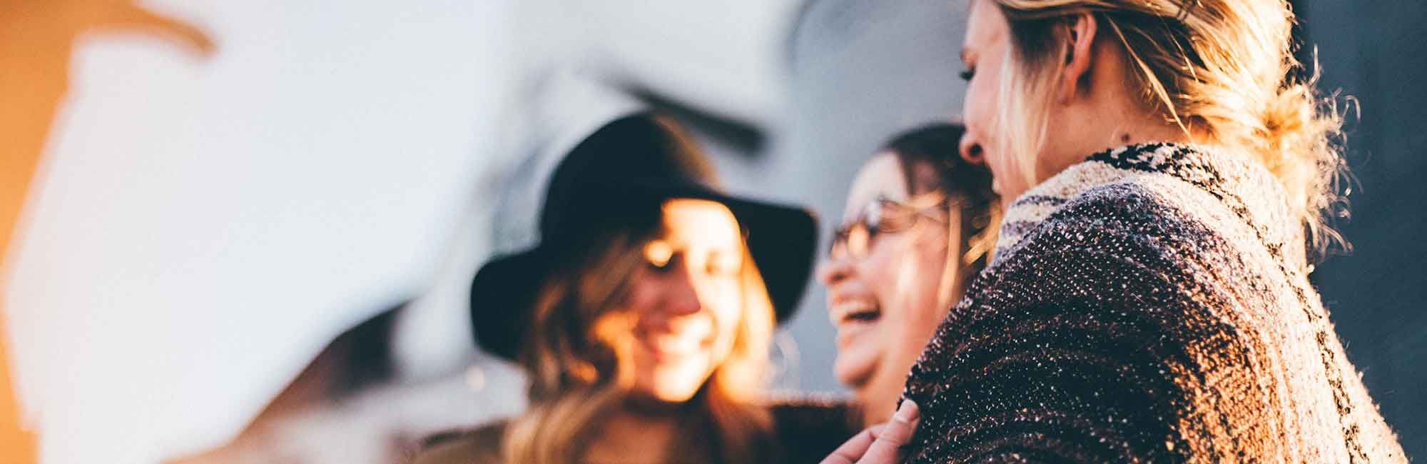 a group of women are standing and laughing to each other